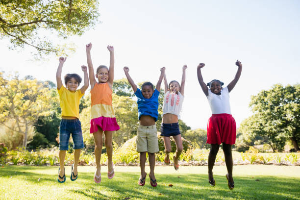 istock Happy kids jumping together during a sunny day 663935140