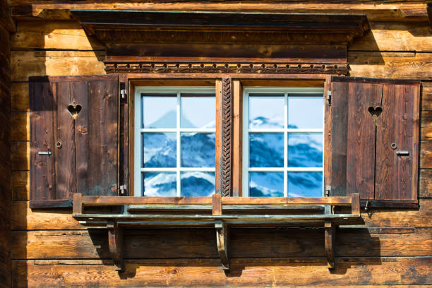 Beautiful wooden window with frozen ice flowers in Norwegian town.