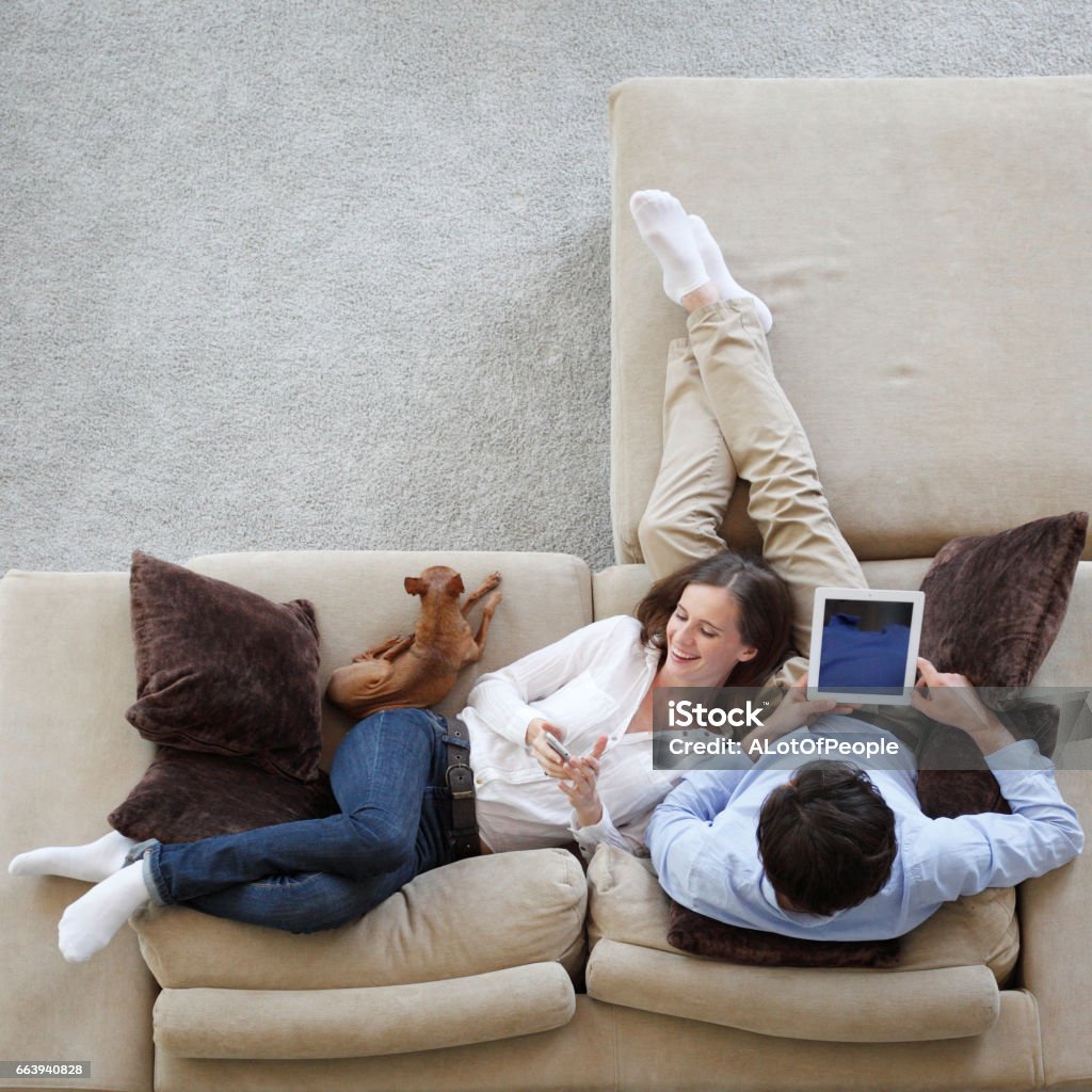 Couple using tablet Couple using digital tablet at home sitting on sofa, top view Digital Tablet Stock Photo