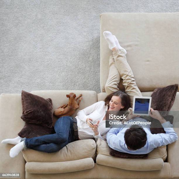 Couple Using Tablet Stock Photo - Download Image Now - Digital Tablet, Sofa, Relaxation