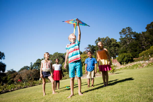 istock Kids playing together during a sunny day with a kite 663947200