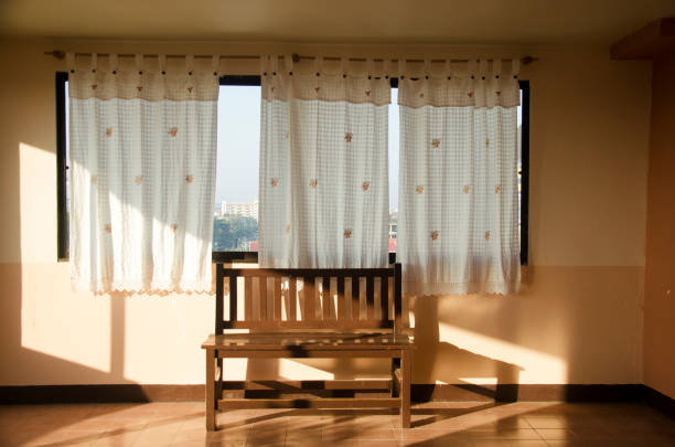 Wooden bench at window in hotel at morning time