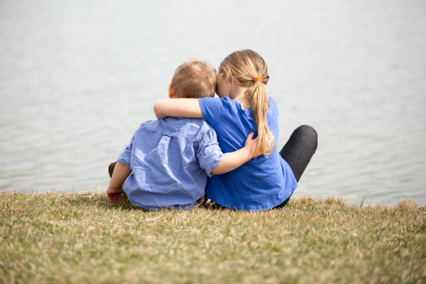 istock Young sibling boy and girl holding eachothr. 663955430