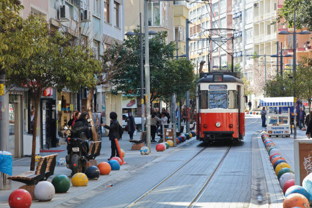 View of a passerby walking alongside a Kadikoy Bahariye streetcar in Istanbul, Turkey on March 07 2017.