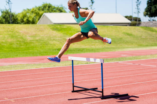 istock Female athlete jumping above the hurdle 663960070