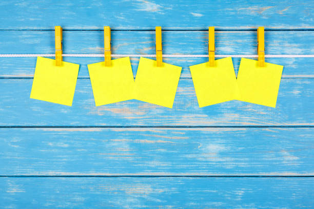 prendedores de roupa amarelas em uma corda com cinco cartas - clothesline clothespin adhesive note bulletin board - fotografias e filmes do acervo