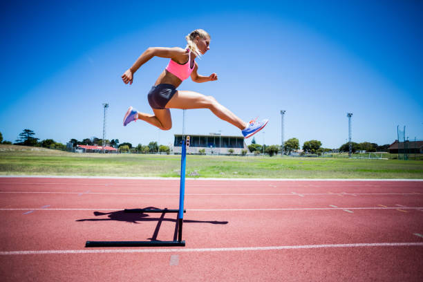 istock Female athlete jumping above the hurdle 663963602