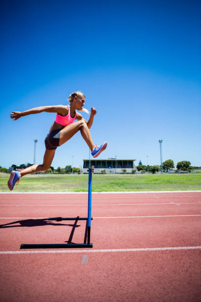 istock Female athlete jumping above the hurdle 663963840