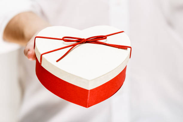 istock Male hand holding a heart-shaped gift box. 663967540