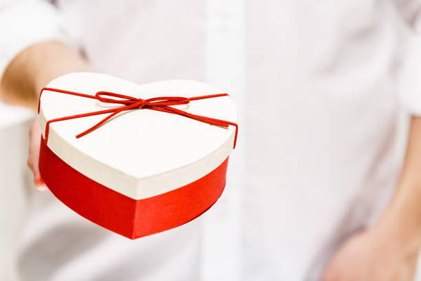 istock Male hand holding a heart-shaped gift box. 663967622
