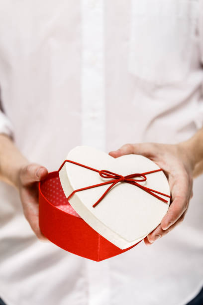istock Male hands holding a heart-shaped gift box. 663970780