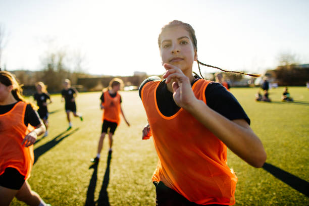 giocatrice di calcio femminile e sua squadra - child playing running group of people foto e immagini stock