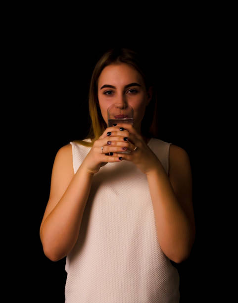 Young pretty girl drinks water Glass of mineral water