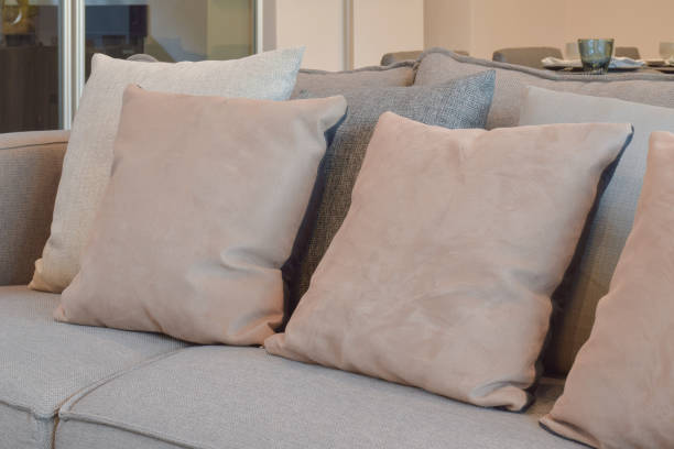 istock Light brown, beige and gray pillows setting on sofa in living room 663974218
