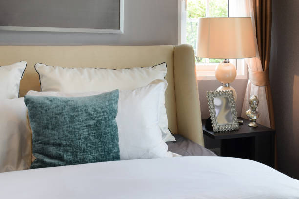 istock bedroom interior design with white and green pillows on white bed and decorative table lamp. 663975146