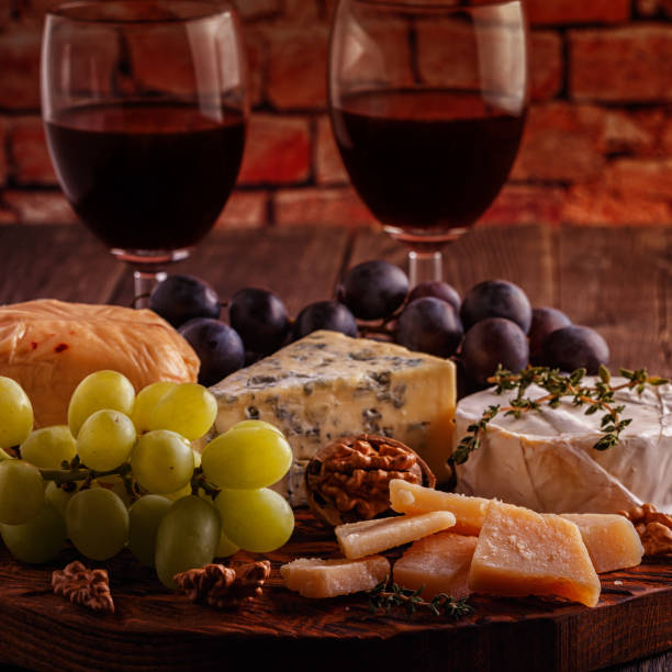 istock Cheese, nuts, grapes and red wine on wooden background 663977940