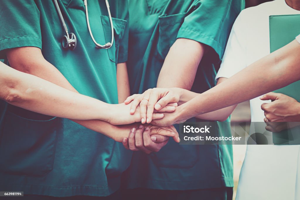 Medici e infermieri coordinano le mani. Lavoro di squadra concettuale - Foto stock royalty-free di Lavoro di squadra