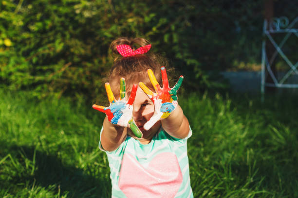 istock Small girl shows painted colorful hands 663981442