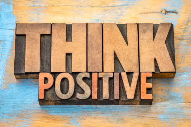 Think positive - word abstract in vintage letterpress wood type blocks against grunge wooden background