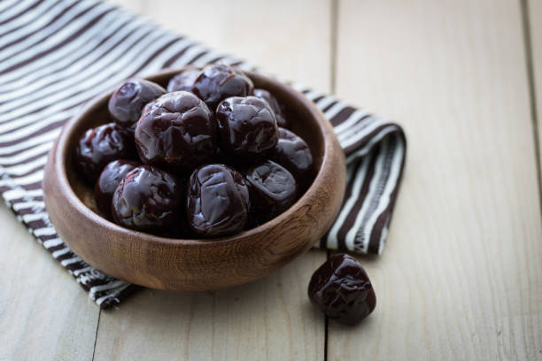 Dried plums on wood floor stock photo