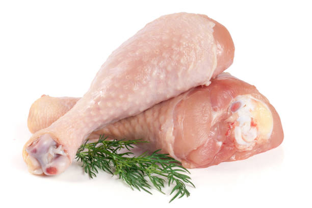 istock Two raw chicken drumsticks with a sprig of dill isolated on white background 663987794