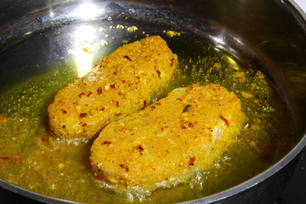 istock Catfish steaks marinated in Indian spices being fried in oil 663988314