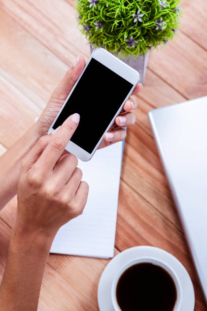 istock Overhead of feminine hands using smartphone 663991442