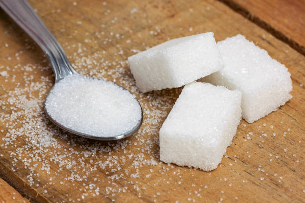 istock sugar cube in the spoon on wood background 663994214