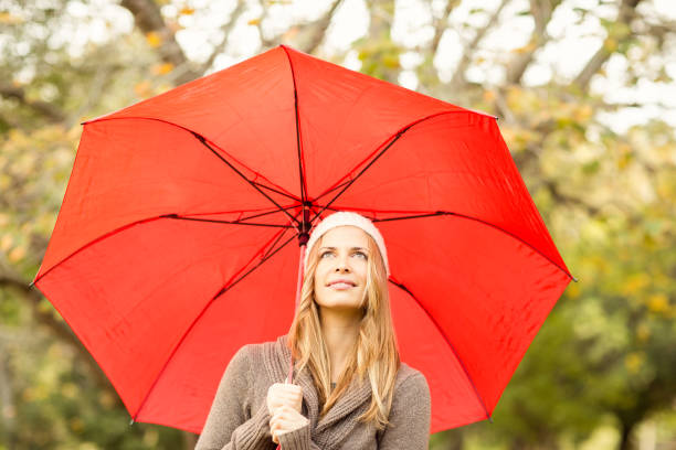 istock Smiling pretty woman under umbrella 663994336