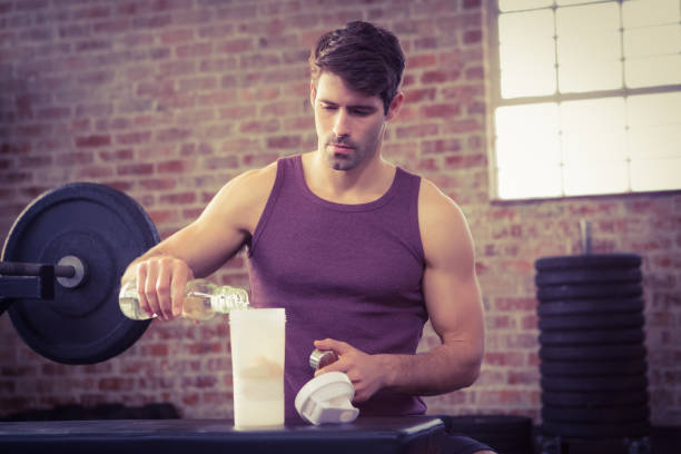 istock Man pouring water into shaker bottle 663994570