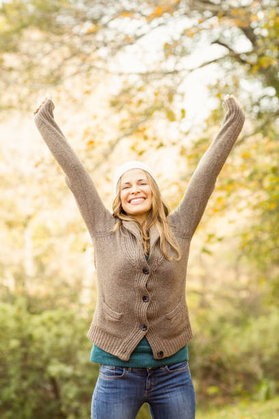 istock Smiling pretty woman with arms raised 663994878
