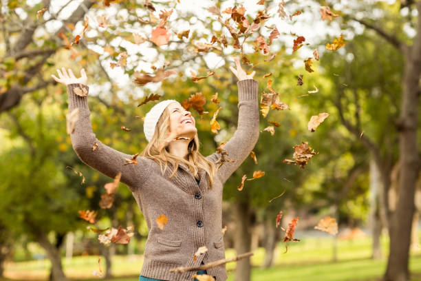 istock Smiling woman throwing leaves around 663994986