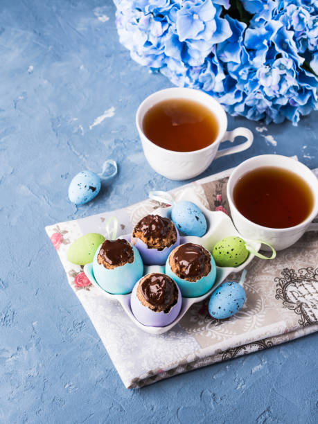 istock Easter sweet cup cakes treets in colorful egg shells on blue 664001604