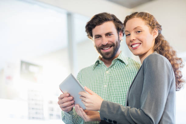 istock Businessman and businesswoman discuss using digital tablet 664004026