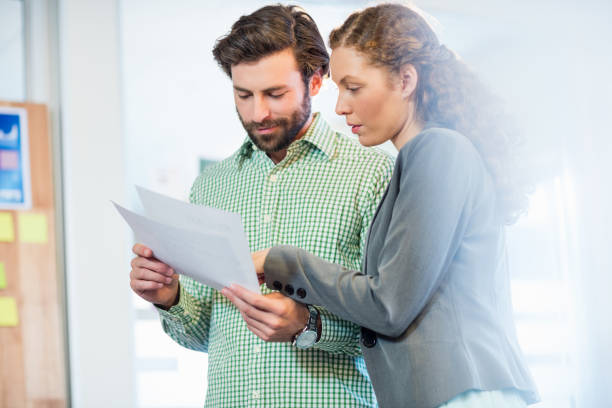 istock Businessman and businesswoman looking at diary 664004444