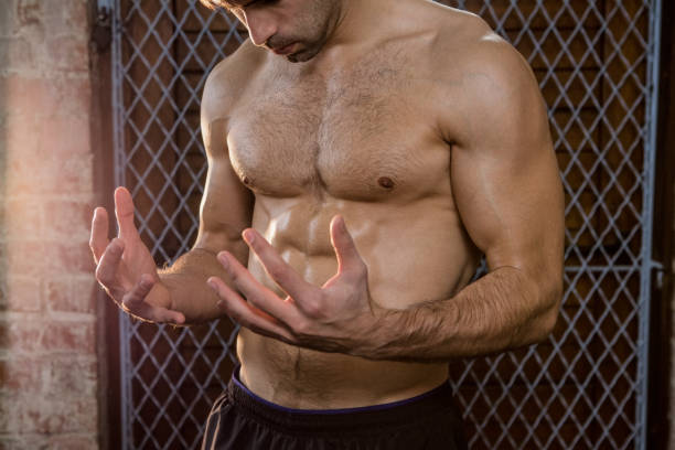 istock Midsection of shirtless man watching his hands 664004774