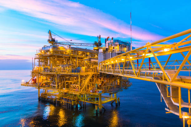 Offshore construction platform for production oil and gas with bridge in evening time stock photo