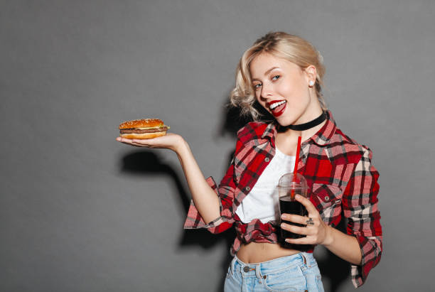 istock Woman with soda showing burger 664011608