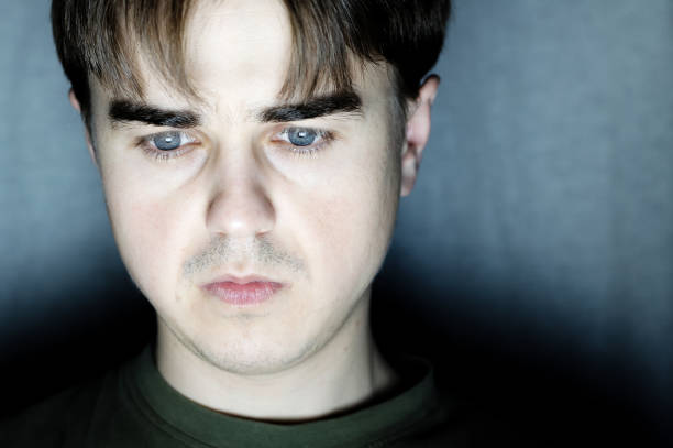 istock young man portrait in dark room at dark background 664012838