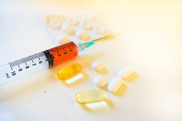 istock Syringe Containing Red Fluid (Blood) Alongside Pills and Blister Pack Close Up 664018312