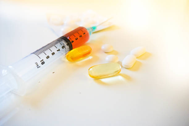 istock Syringe Containing Red Fluid (Blood) Alongside Pills and Blister Pack Low Angle 664018622