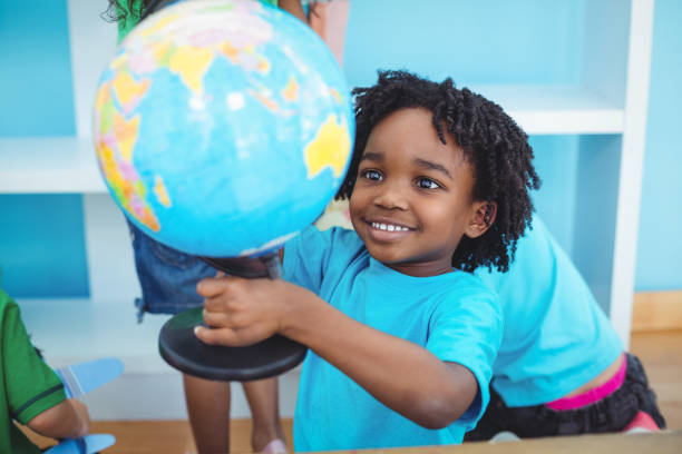 istock Small boy holding a globe of the world 664022056