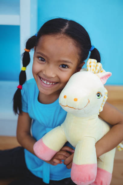 istock Small girl holding a pony teddy 664022288