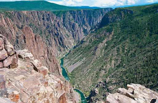 Deep steep, narrow canyons, cliffs, old rock, craggy spires, vertical, rock, water and sky wilderness surrounding the Gunnison River.
