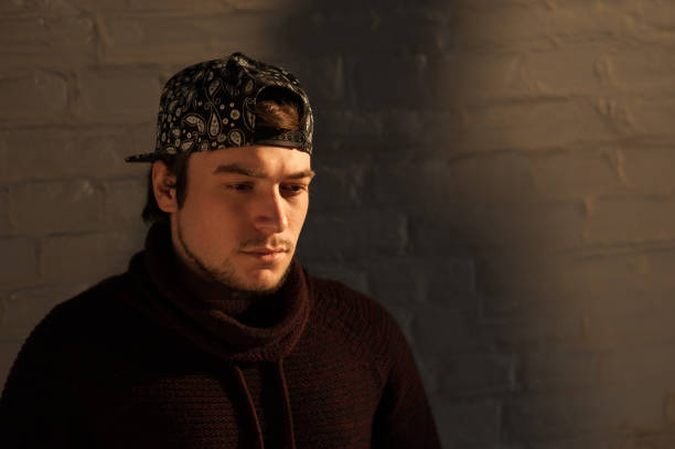 istock Handsome young man in a baseball cap against brick wall background 664026150
