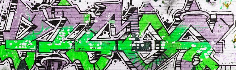 Colorful graffiti drawn on the wall of an abandoned building, during the day