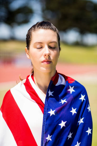 istock Female athlete wrapped in american flag 664039814