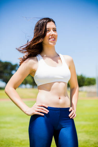 istock Happy female athlete standing with hand on hip 664042908