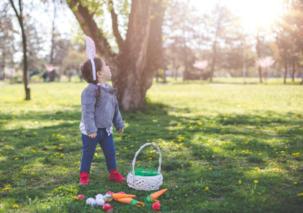 istock Baby girl looking up - Easter background 664043718