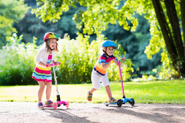 istock Kids riding scooter in summer park. 664046442